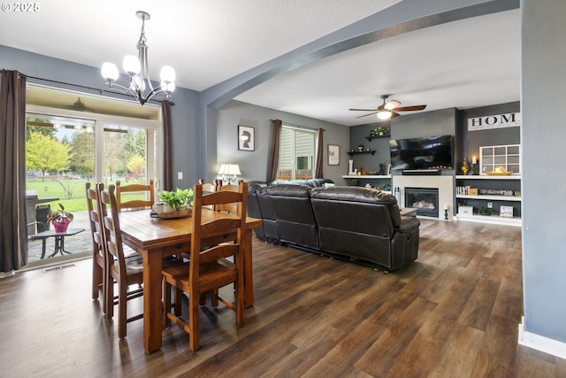 4219 NE 157th Ct, Vancouver, WA 98682 - dining space with dark wood-type flooring, a wealth of natural light, arched walkways, and a glass covered fireplace