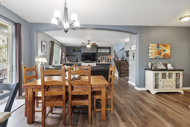 4219 NE 157th Ct, Vancouver, WA 98682 - dining area featuring ceiling fan with notable chandelier, dark wood-type flooring, arched walkways, stairs, and baseboards