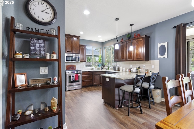 4219 NE 157th Ct, Vancouver, WA 98682 - kitchen featuring open shelves, plenty of natural light, a sink, appliances with stainless steel finishes, and a peninsula