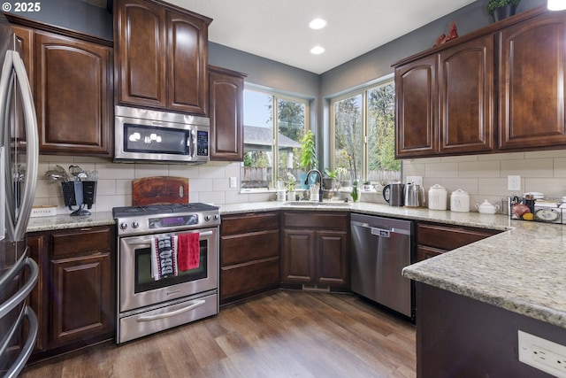 4219 NE 157th Ct, Vancouver, WA 98682 - kitchen with a sink, light stone countertops, dark wood-type flooring, decorative backsplash, and stainless steel appliances