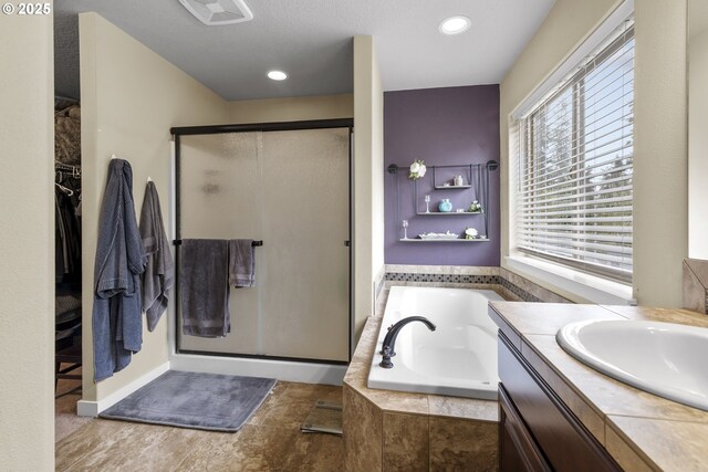 4219 NE 157th Ct, Vancouver, WA 98682 - bathroom featuring visible vents, a bath, a spacious closet, vanity, and a stall shower