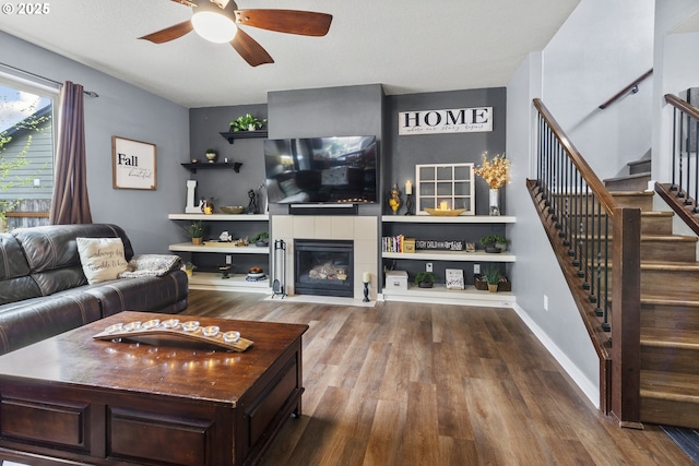 4219 NE 157th Ct, Vancouver, WA 98682 - living area featuring a ceiling fan, wood finished floors, a tiled fireplace, stairs, and baseboards