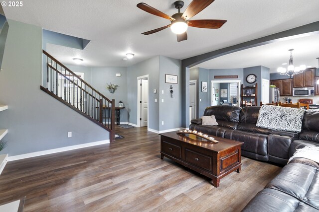 4219 NE 157th Ct, Vancouver, WA 98682 - living room with baseboards, arched walkways, stairway, wood finished floors, and ceiling fan with notable chandelier