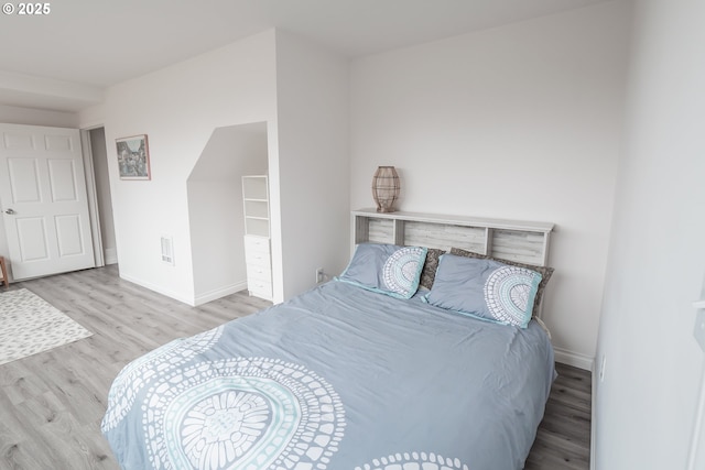 bedroom featuring wood finished floors and baseboards