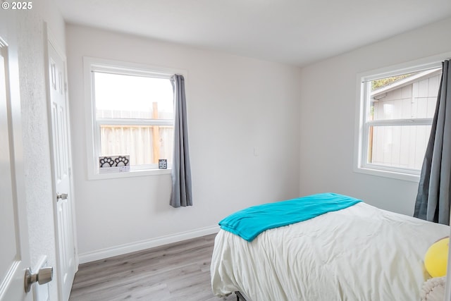 bedroom with light wood-style floors and baseboards