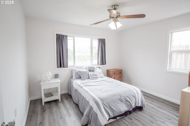 bedroom with light wood-style flooring, baseboards, and a ceiling fan