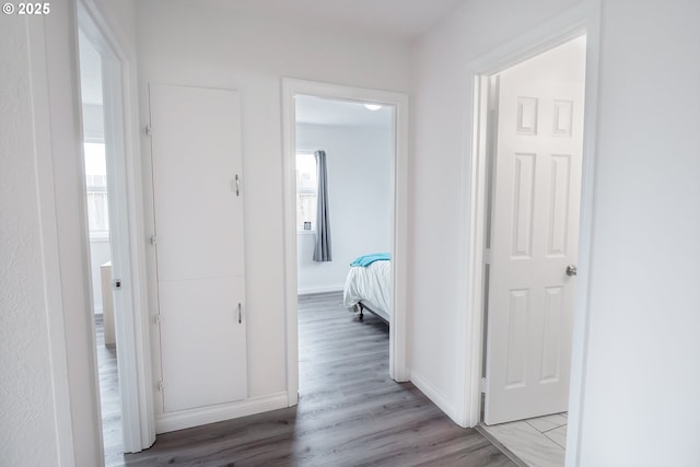 hall with light wood finished floors and baseboards