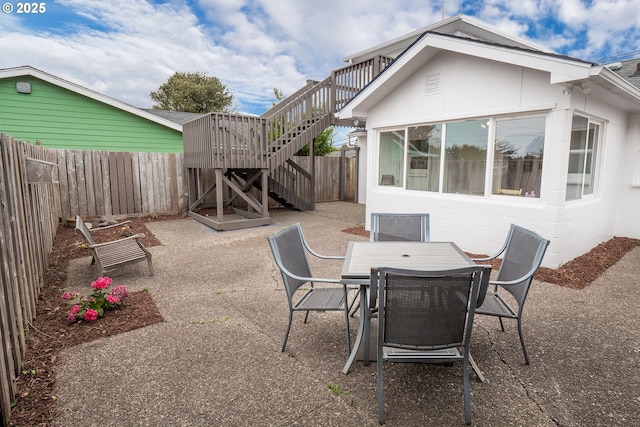 view of patio with a fenced backyard, stairs, and outdoor dining area