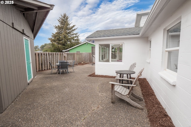 view of patio featuring outdoor dining space and fence