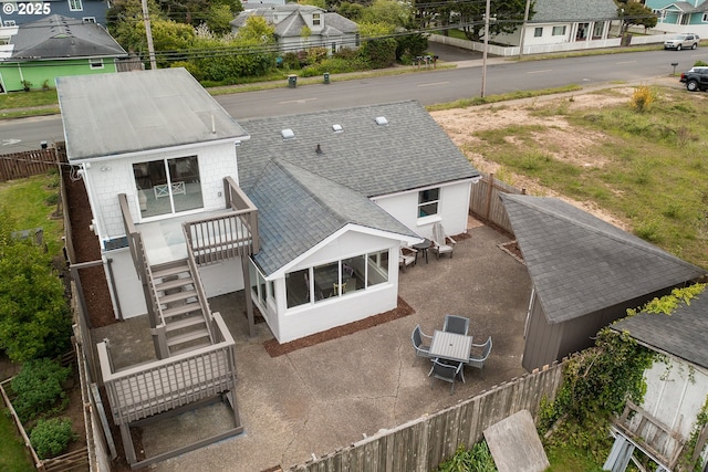 back of property with a fenced backyard, a patio area, and a shingled roof