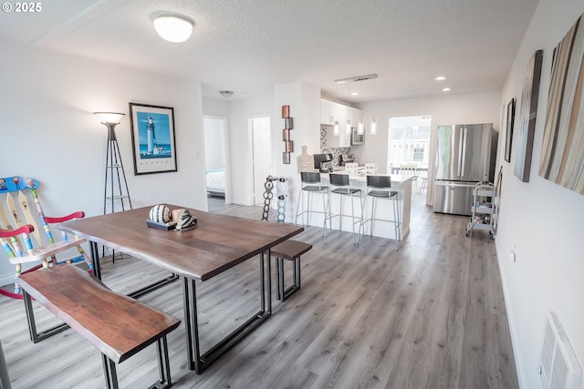 dining space featuring light wood-style flooring and recessed lighting
