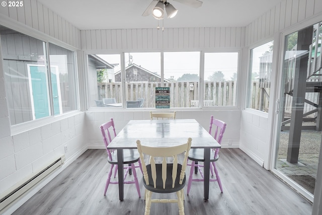 sunroom / solarium with baseboard heating, wood finished floors, and a wooden deck