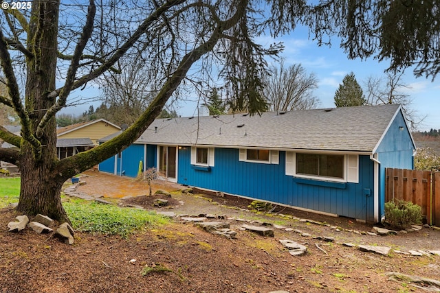 view of front of property with a shingled roof and fence