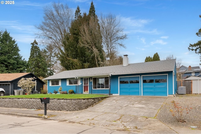 single story home with a front lawn, concrete driveway, central AC unit, a chimney, and a garage