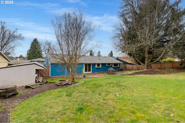 back of house featuring a lawn and fence