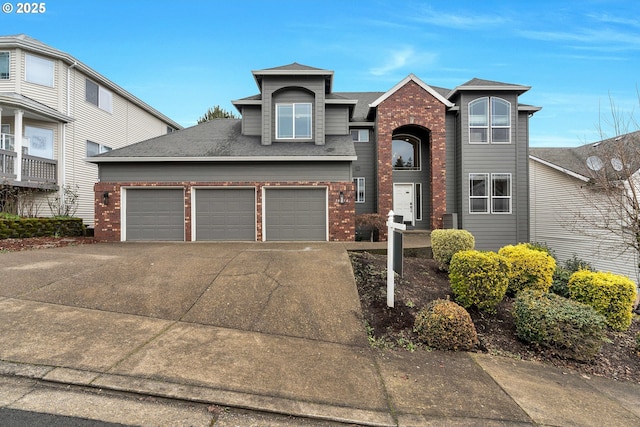 view of front facade with a garage, concrete driveway, brick siding, and roof with shingles