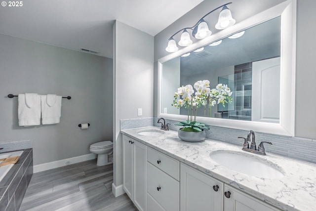 1852 SE Oar Dr, Lincoln City, OR 97367 - full bathroom with double vanity, a bath, tasteful backsplash, toilet, and baseboards