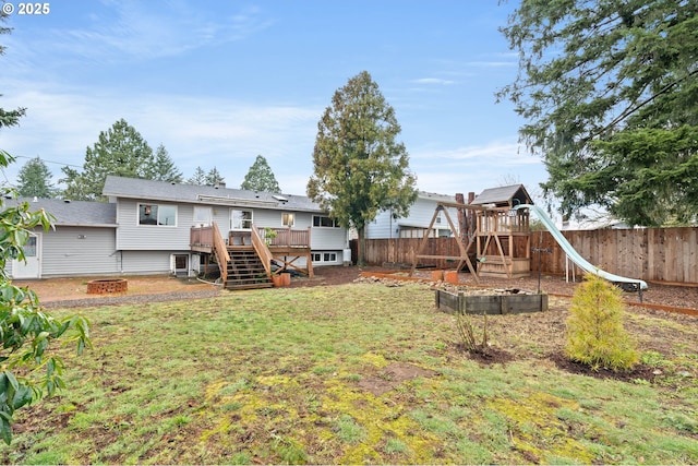 back of house featuring an outdoor fire pit, fence, a garden, stairs, and a yard