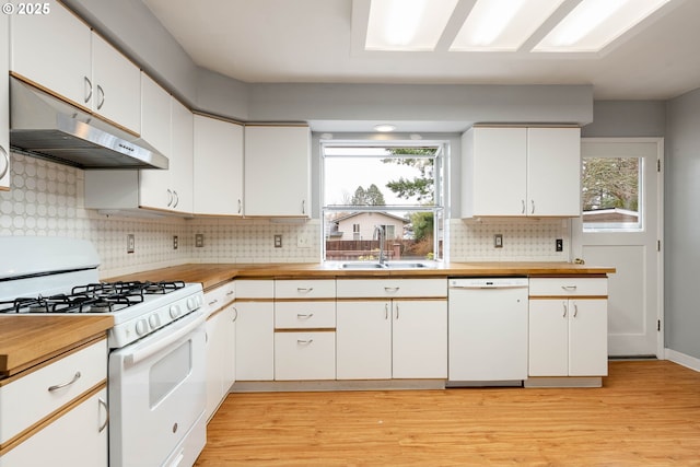 kitchen featuring white appliances, light countertops, under cabinet range hood, white cabinetry, and a sink