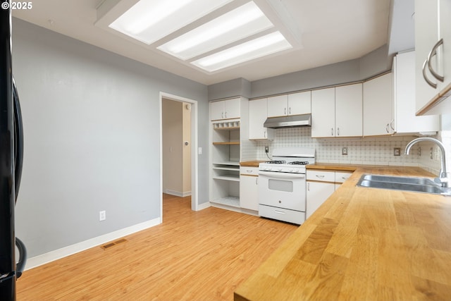 kitchen with under cabinet range hood, a sink, white cabinets, wooden counters, and white gas range oven