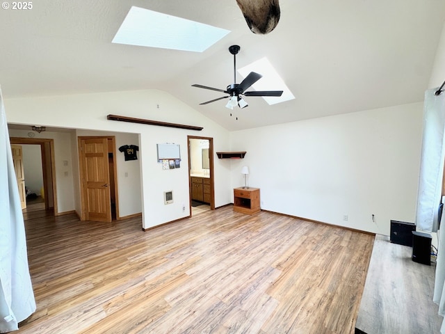 38434 Mckenzie Hwy, Springfield, OR 97478 - unfurnished living room featuring a skylight, light wood finished floors, vaulted ceiling, baseboards, and a ceiling fan