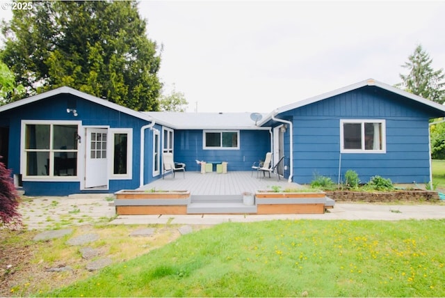 rear view of house with a yard and a deck