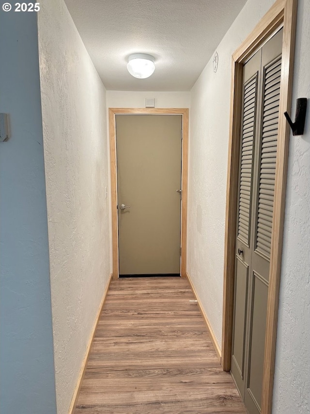 38434 Mckenzie Hwy, Springfield, OR 97478 - hallway with a textured wall, light wood-style flooring, a textured ceiling, and baseboards