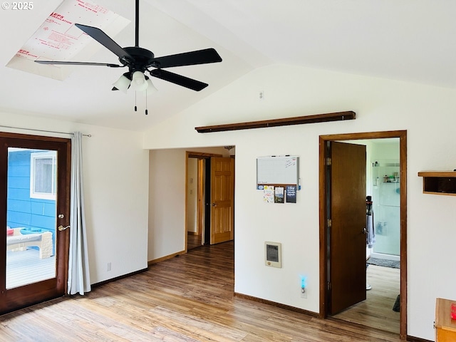 spare room featuring lofted ceiling, light wood-type flooring, ceiling fan, and baseboards