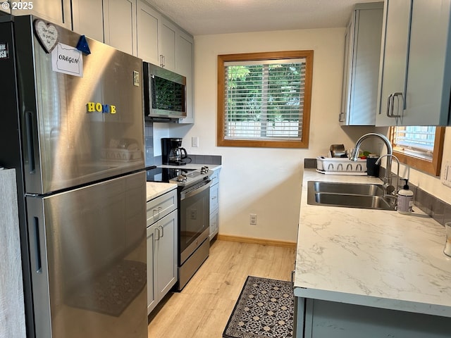38434 Mckenzie Hwy, Springfield, OR 97478 - kitchen with stainless steel appliances, gray cabinets, a sink, light wood-type flooring, and healthy amount of natural light