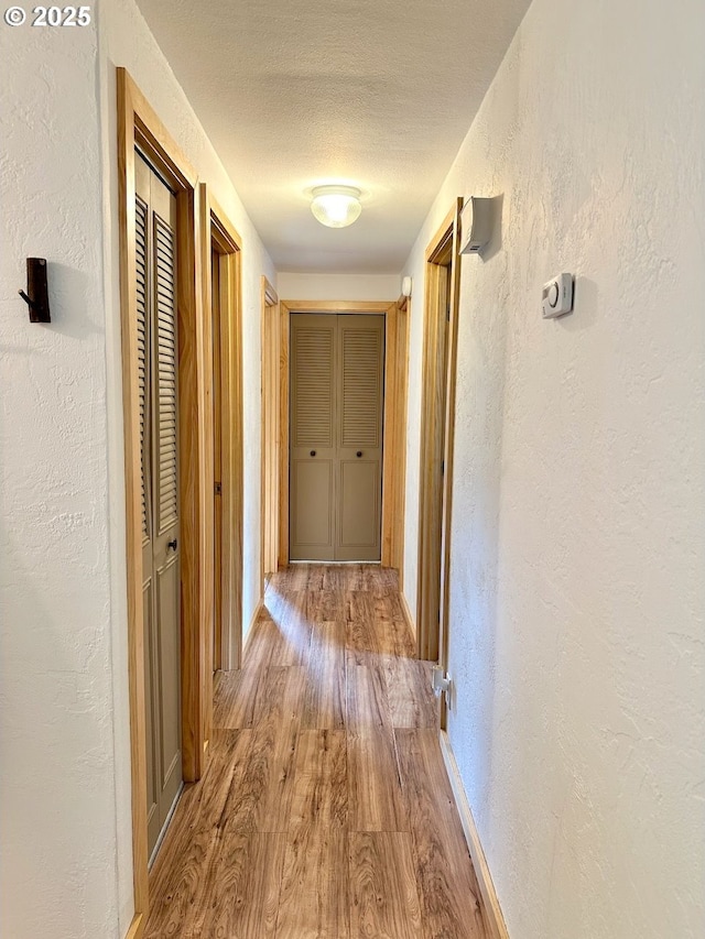 38434 Mckenzie Hwy, Springfield, OR 97478 - hallway featuring a textured wall, wood finished floors, a textured ceiling, and baseboards