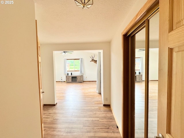 38434 Mckenzie Hwy, Springfield, OR 97478 - corridor with light wood-type flooring, a textured ceiling, and baseboards