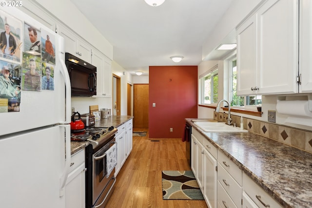 178 NE Tari Ln, Stevenson, WA 98648 - kitchen featuring white cabinets, a sink, stainless steel electric range oven, freestanding refrigerator, and black microwave