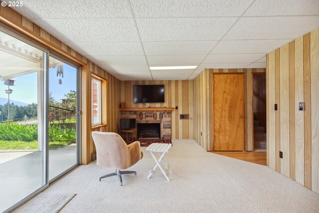 178 NE Tari Ln, Stevenson, WA 98648 - sitting room with carpet, a fireplace with raised hearth, a drop ceiling, and wood walls