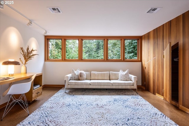 321 NW Hilltop Dr, Portland, OR 97210 - carpeted living room with a desk, track lighting, wood walls, and baseboards