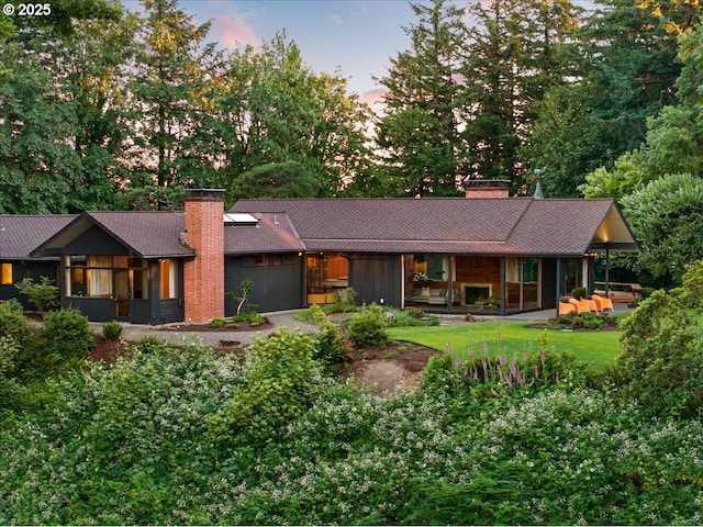 321 NW Hilltop Dr, Portland, OR 97210 - view of front of home with a chimney, an attached garage, and view of wooded area