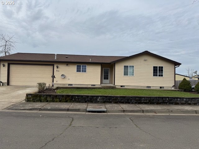 single story home featuring driveway, a garage, and a front yard