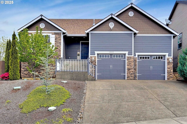 craftsman house with driveway, stone siding, and a garage