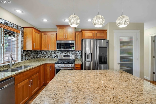 kitchen featuring decorative backsplash, dark wood-style flooring, light stone countertops, a sink, and appliances with stainless steel finishes
