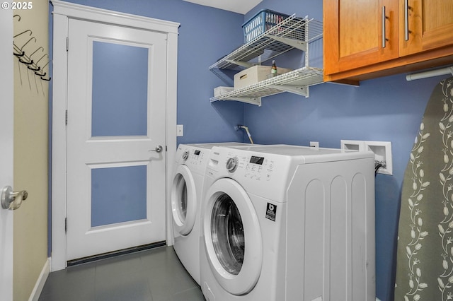 laundry room with tile patterned floors, baseboards, cabinet space, and washer and dryer