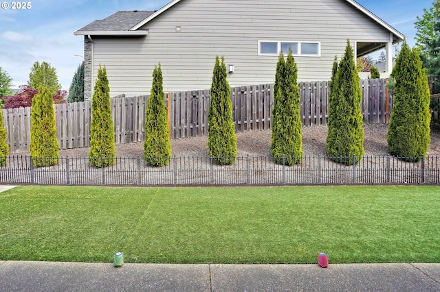 view of side of property featuring a lawn and fence