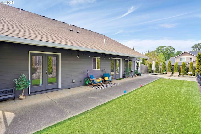 back of house with fence, a patio, french doors, a shingled roof, and a yard