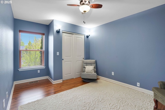 unfurnished room with visible vents, a ceiling fan, baseboards, and wood finished floors