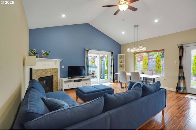 living room featuring a ceiling fan, a fireplace, wood finished floors, high vaulted ceiling, and recessed lighting