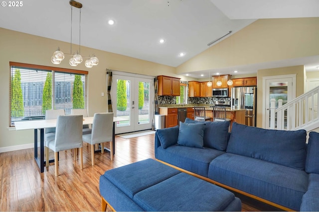 living room featuring recessed lighting, light wood finished floors, baseboards, and vaulted ceiling