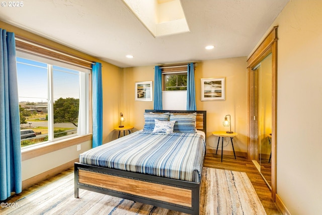 1201 NW Bayshore Dr, Waldport, OR 97394 - bedroom with wood finished floors, baseboards, a skylight, and recessed lighting