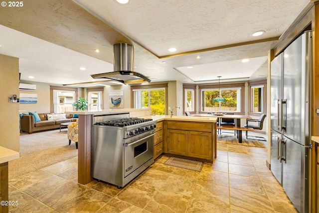 1201 NW Bayshore Dr, Waldport, OR 97394 - kitchen featuring high quality appliances, island exhaust hood, open floor plan, light countertops, and brown cabinetry