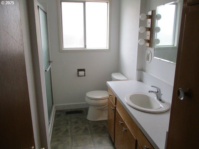 1210 Alder St, Elgin, OR 97827 - full bathroom with an enclosed shower, vanity, plenty of natural light, and toilet