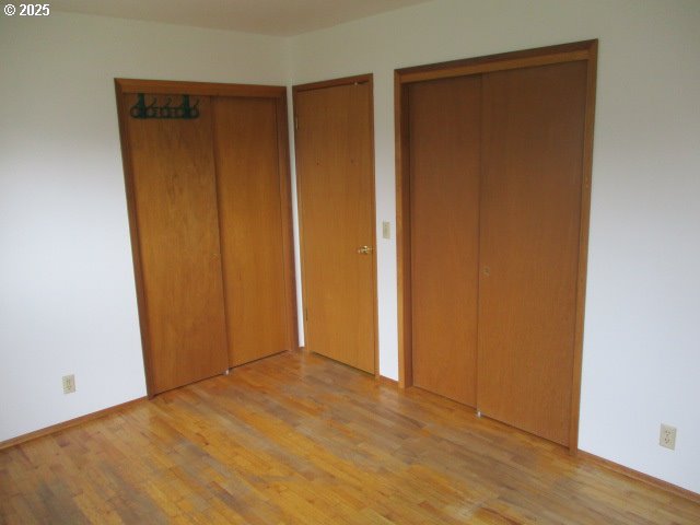 1210 Alder St, Elgin, OR 97827 - unfurnished bedroom featuring multiple closets and wood finished floors