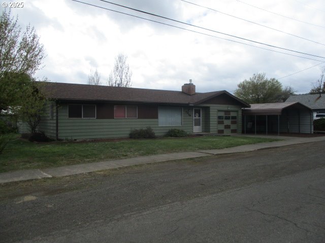 1210 Alder St, Elgin, OR 97827 - single story home with an attached garage, driveway, and a front lawn