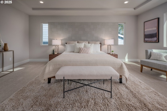 bedroom with a raised ceiling and light carpet